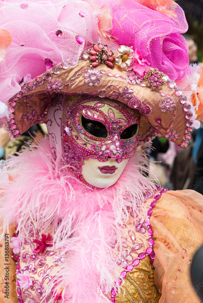 Masques de venise et costumes de carnaval. Ton rose et orange. Regard triste.