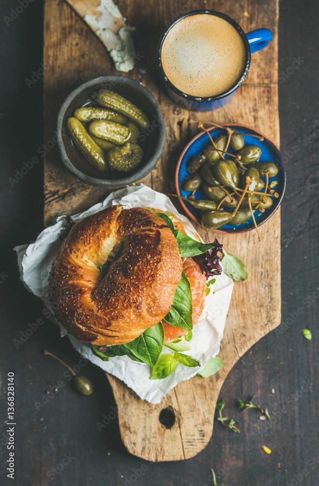 Breakfast with bagel with salmon, avocado, cream-cheese, basil, espresso coffee in blue mug, pickles