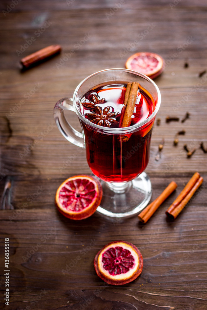 mulled wine with spices in cup on wooden background