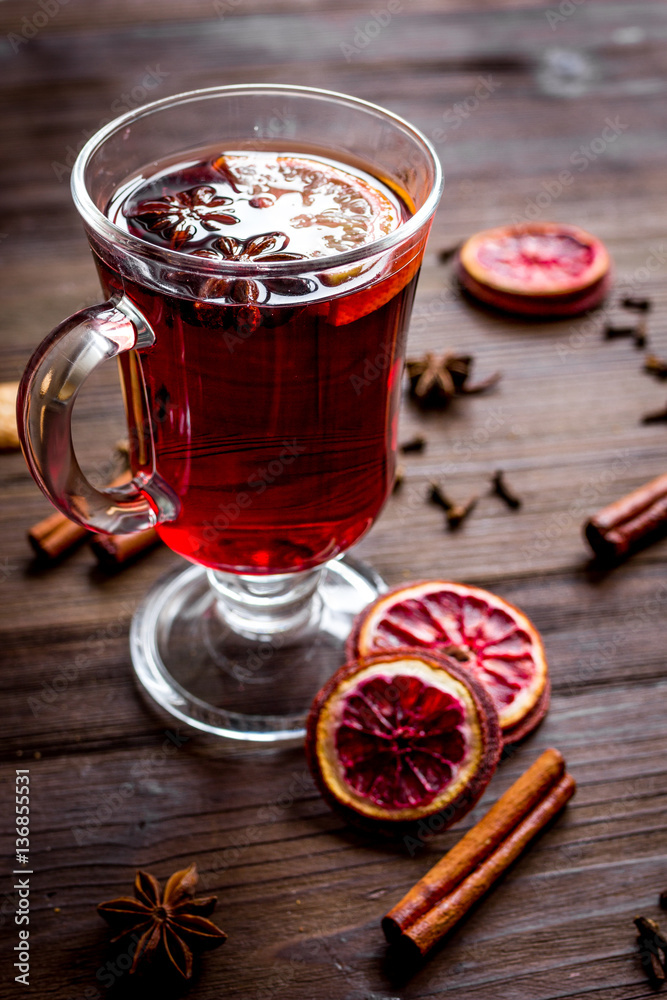 mulled wine with spices in cup on wooden background