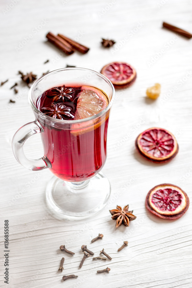 mulled wine with spices in cup on wooden background