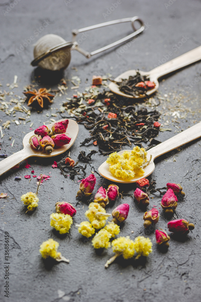 Spoons and herbs on grey background