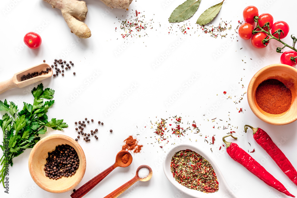 spices in wooden spoon on white background top view