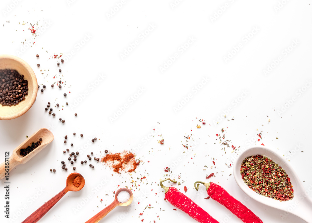 spices in wooden spoon on white background top view