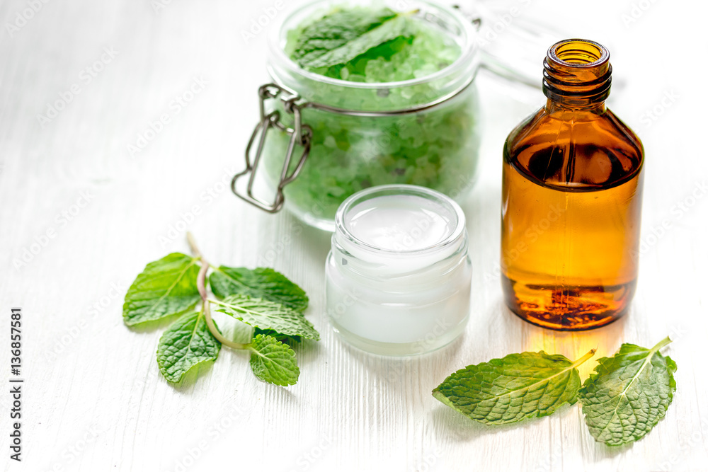 organic cosmetics with herbal extracts of mint on wooden background