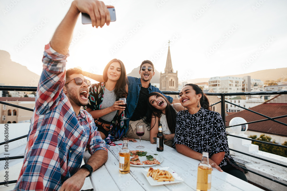 Friends on rooftop party taking selfie