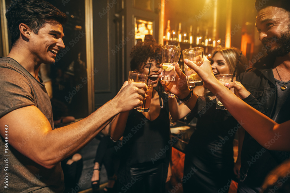 Group of men and women enjoying drinks at nightclub