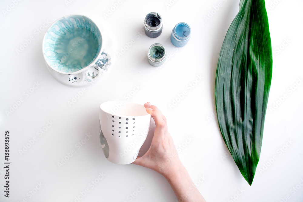 painted ceramic cup on white background top view