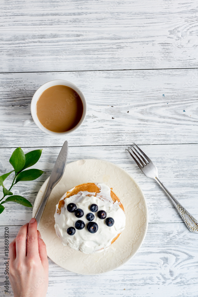 Breakfast concept with flowers on wooden background top view