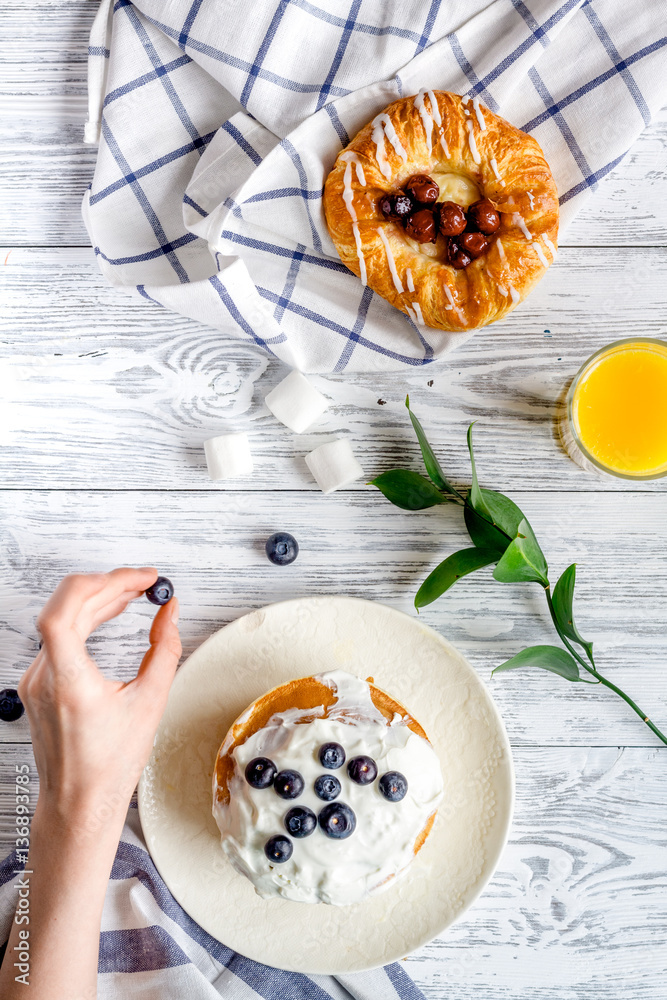 Breakfast concept with flowers on wooden background top view