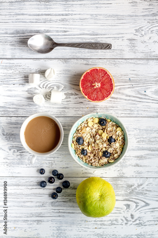 Breakfast concept with flowers on wooden background top view