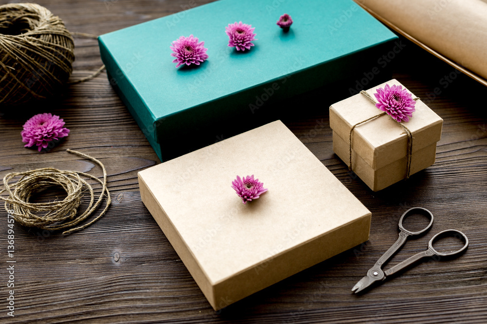 wrapping gifts in box for holiday on wooden background