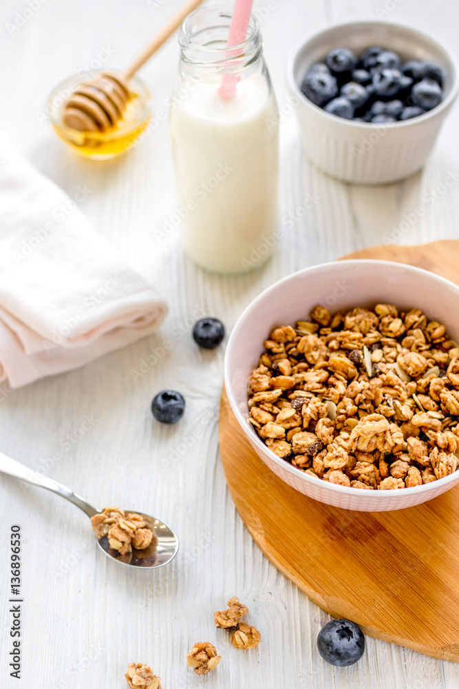 Fitness breakfast with granola, milk and honey on white background