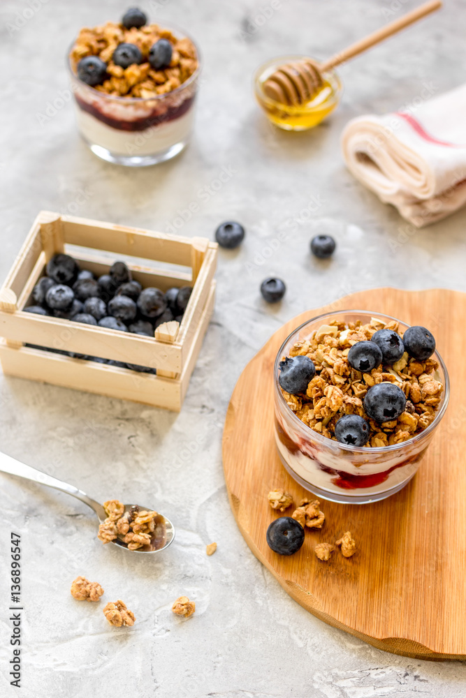 Morning granola with yogurt, honey and berries on white table