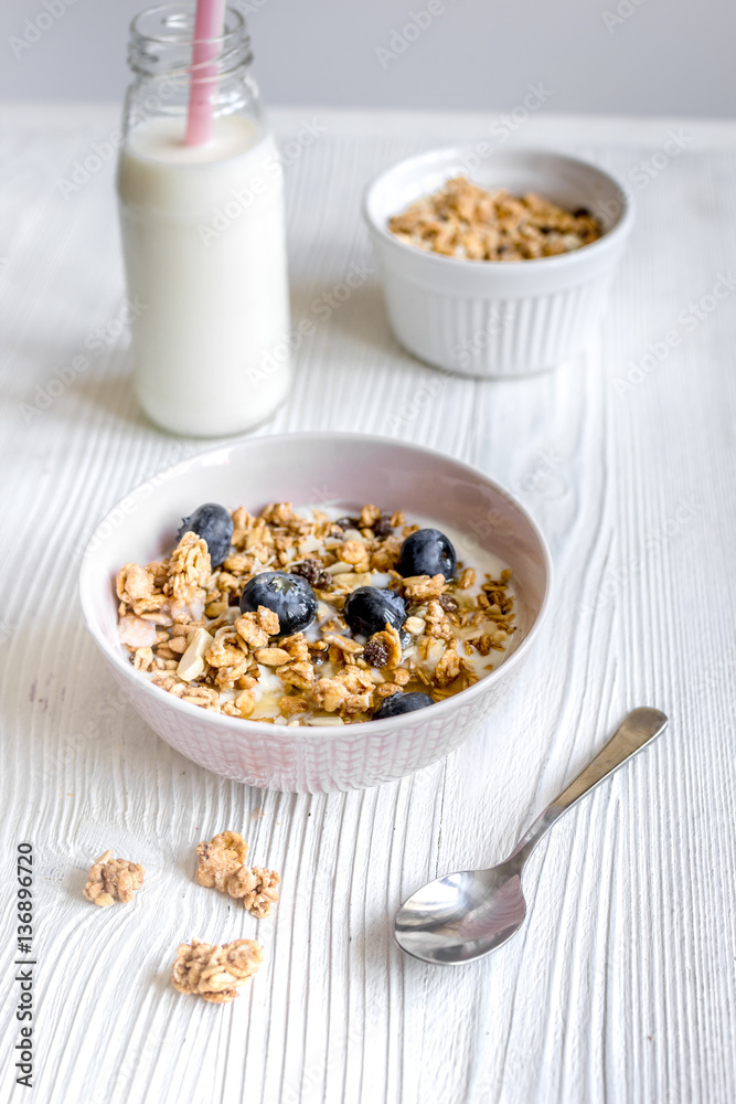 Homemade fitness granola with yoghurt and berries on white kitchen background