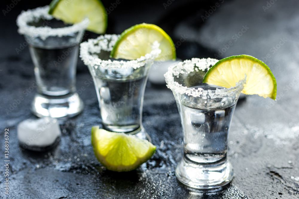 Alcohol shots with lime and salt on black background