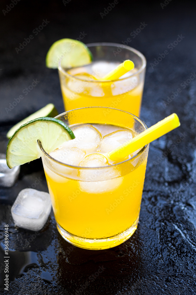 Alcohol cocktails with lime and ice on dark background