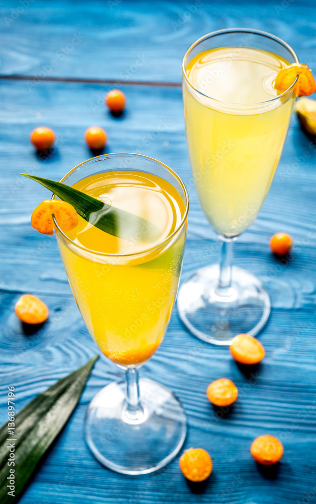 cocktail with physalis in glass on wooden background