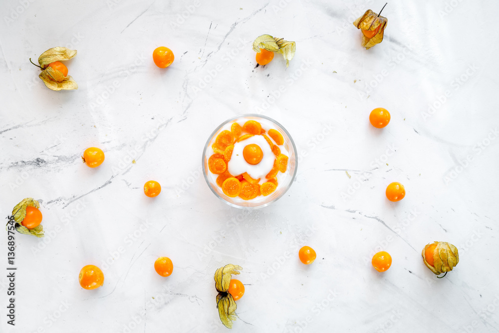 yogurt with physalis on stone background top view