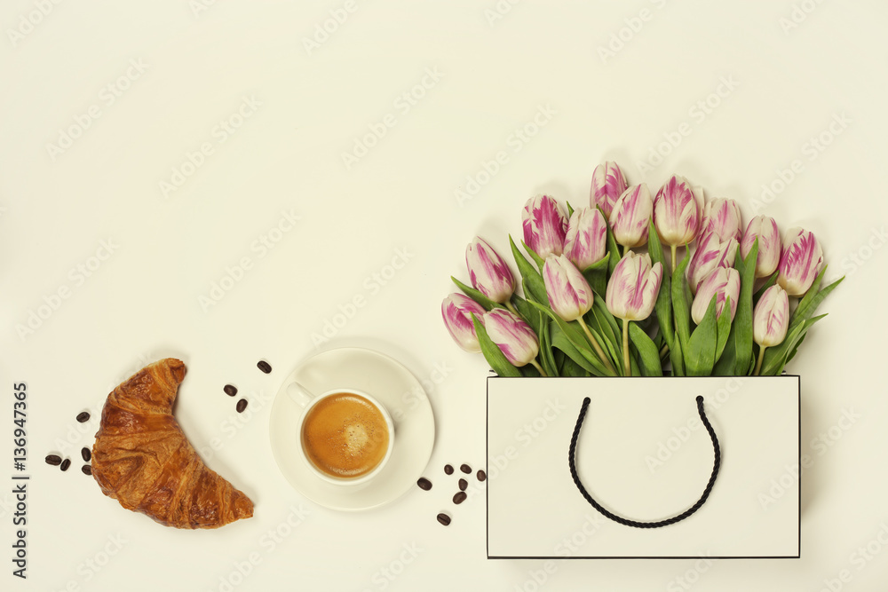 Top view of spring flowers, coffee and croissant