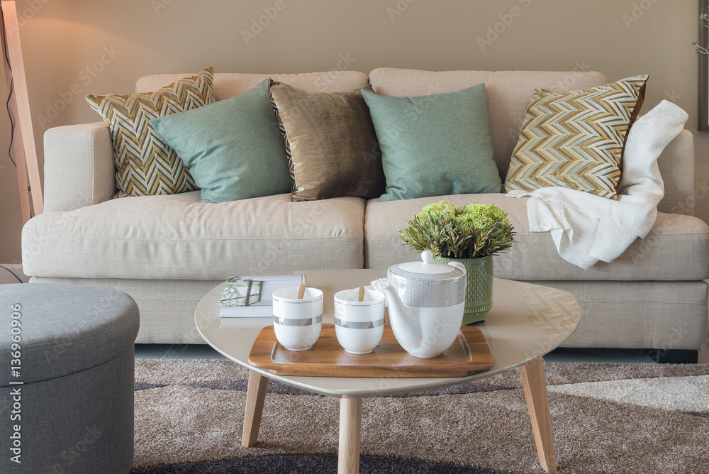 modern living room with green pillows on cozy sofa and wooden la