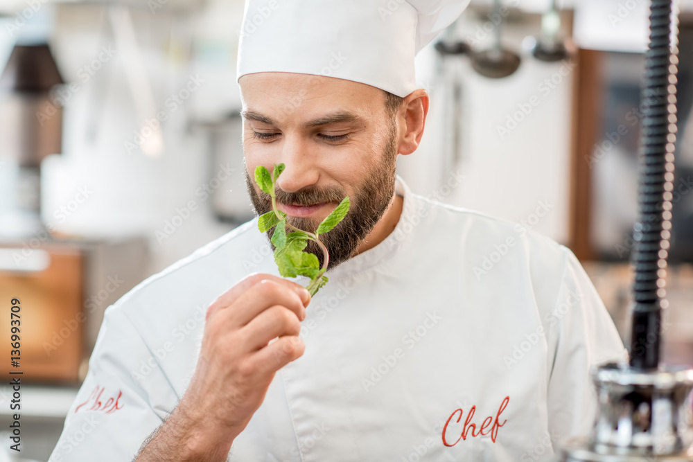 Handsome chef cook checking the freshness of green mint at the restaurant kitchen