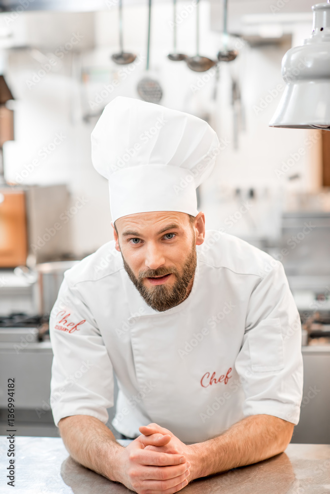 Portrait of a chef cook in uniform at the restaurant kitchen