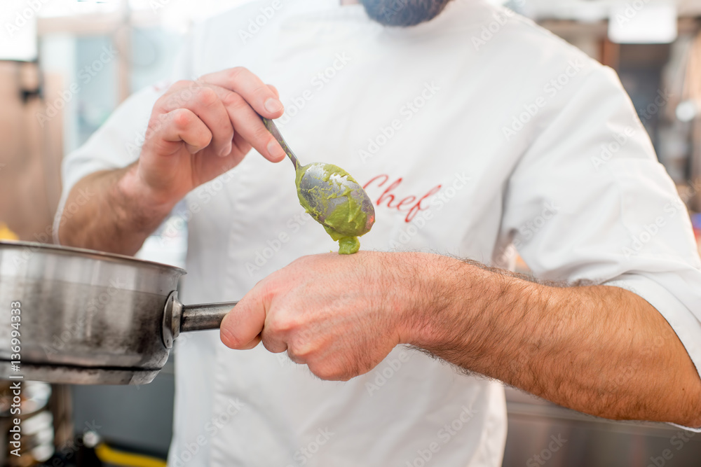 Chef cook putting sause on the hand for tasting