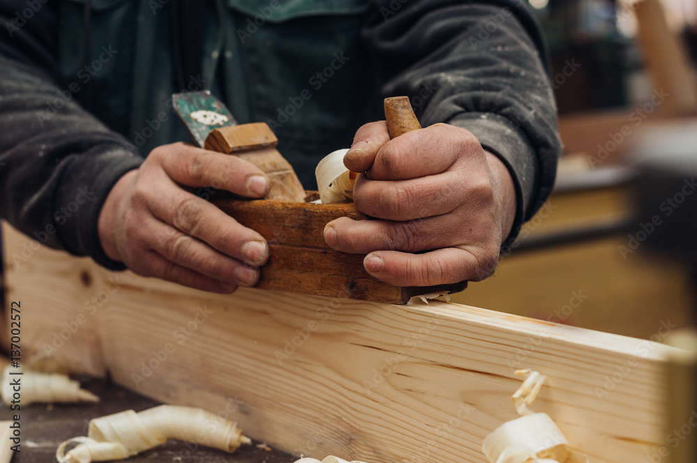 Man using hand plane in workshop