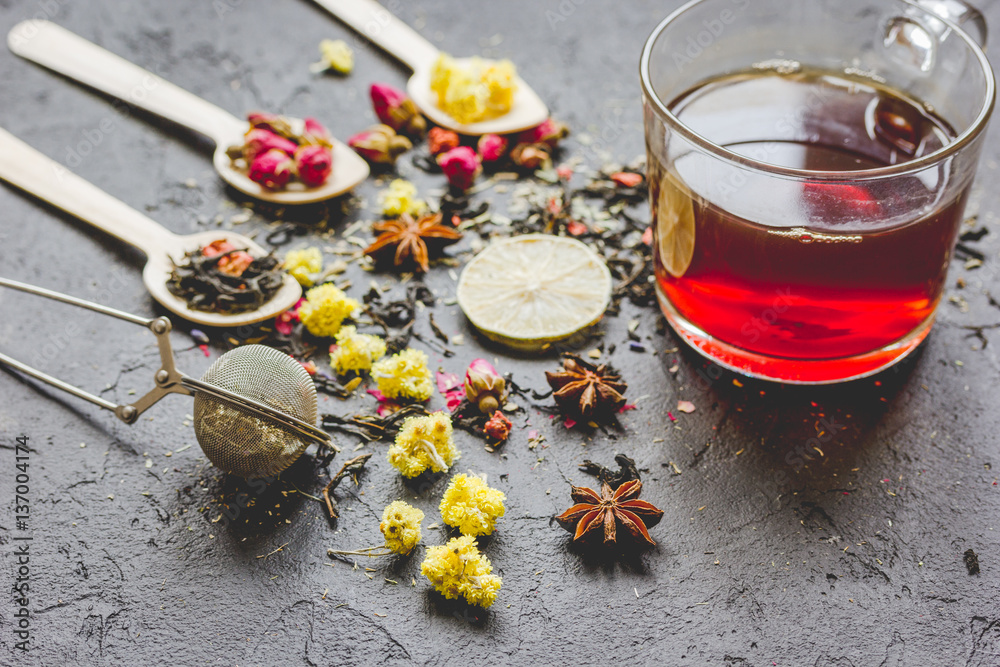 Teacup and herbs on grey background