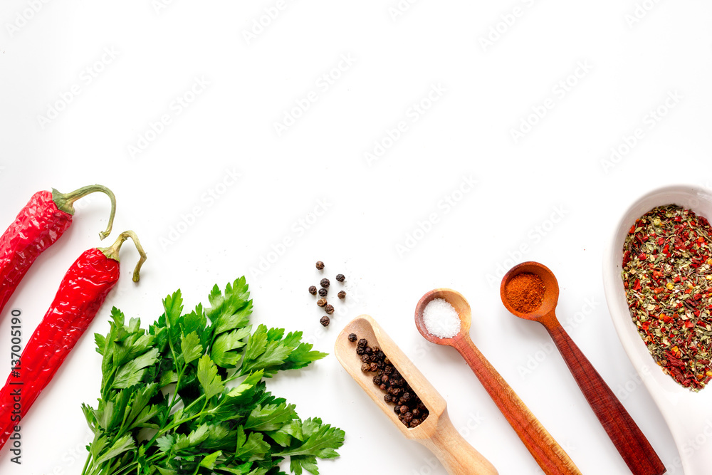 spices in wooden spoon on white background top view