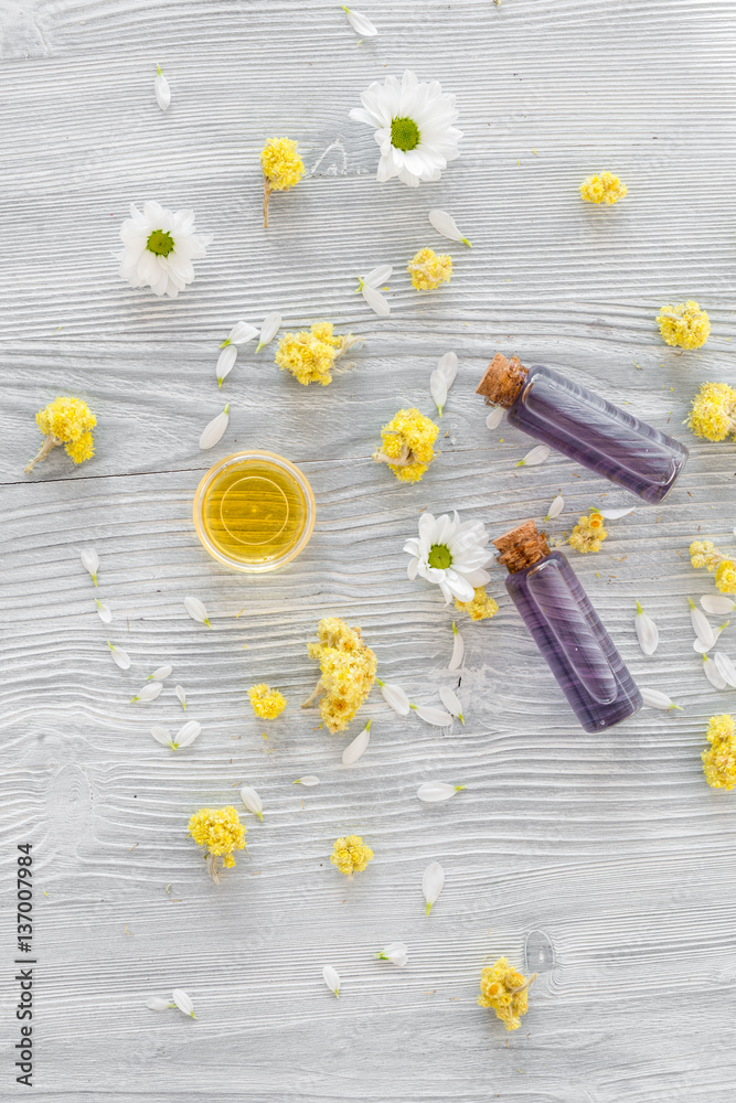 organic cosmetics with camomile on wooden background top view