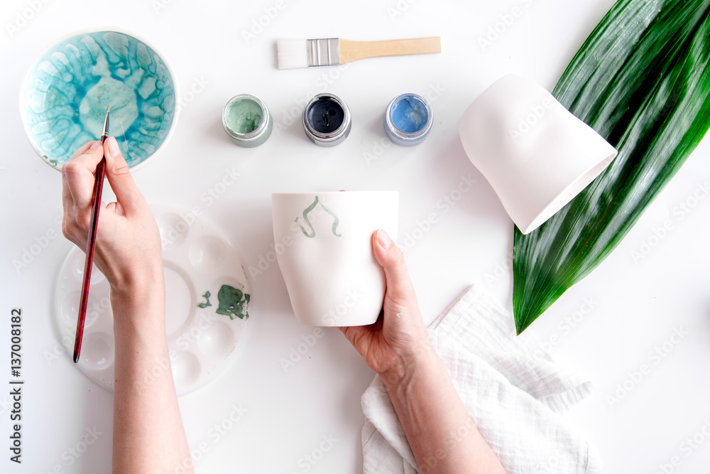 painted ceramic cup on white background top view