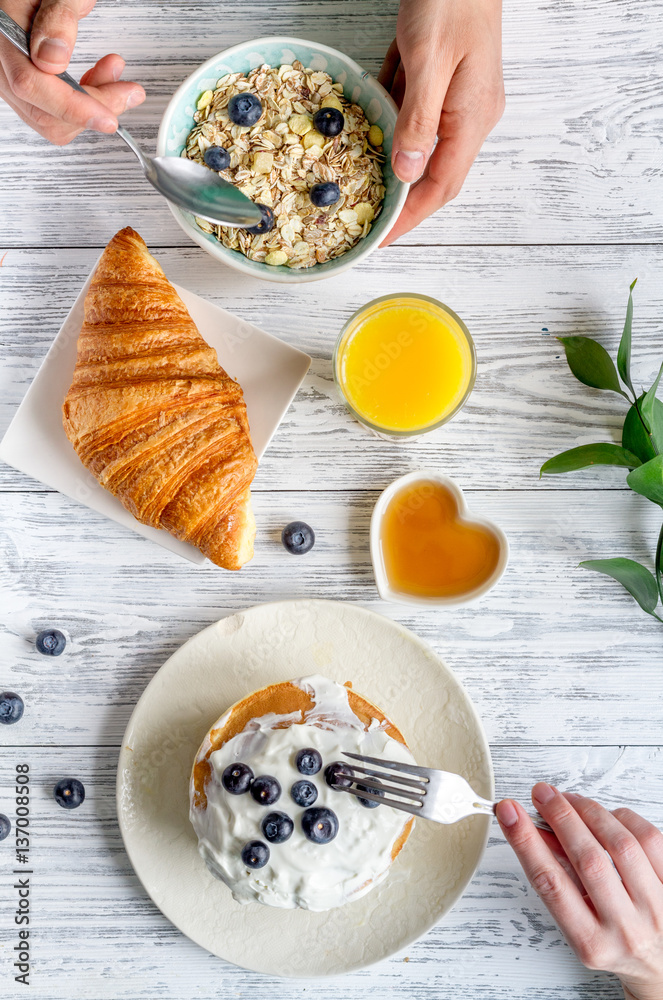 Breakfast concept with flowers on wooden background top view