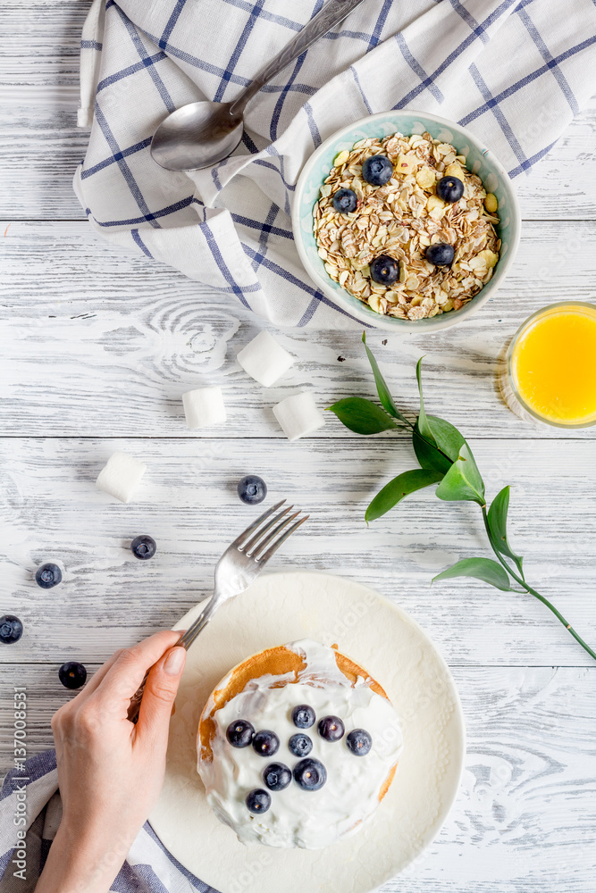 Breakfast concept with flowers on wooden background top view