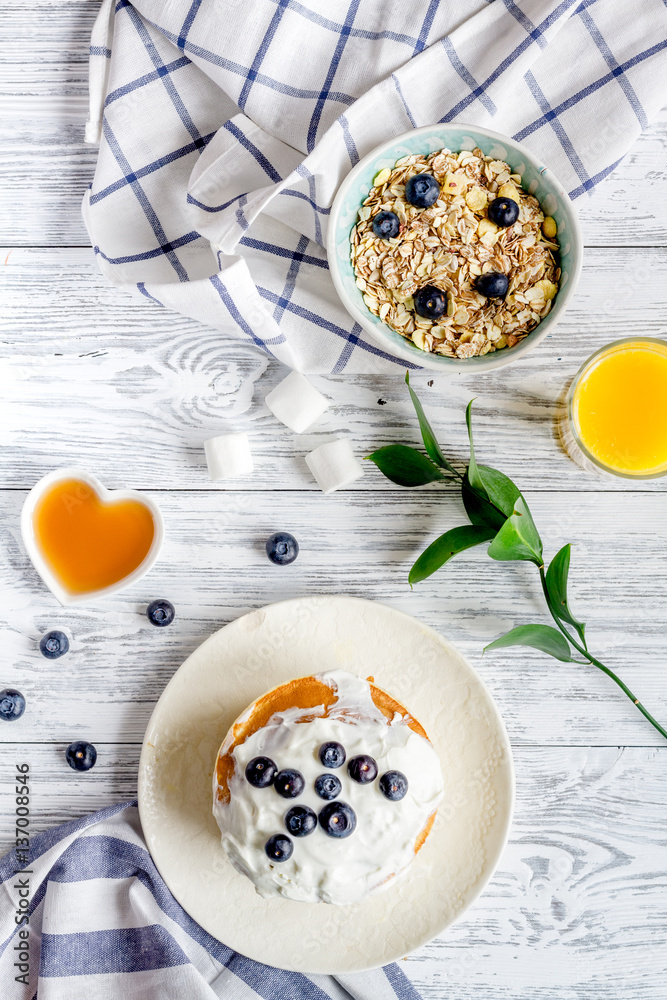 Breakfast concept with flowers on wooden background top view