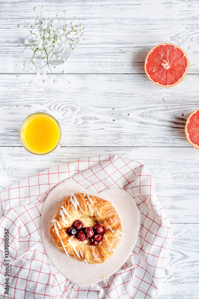 Breakfast concept with flowers on wooden background top view