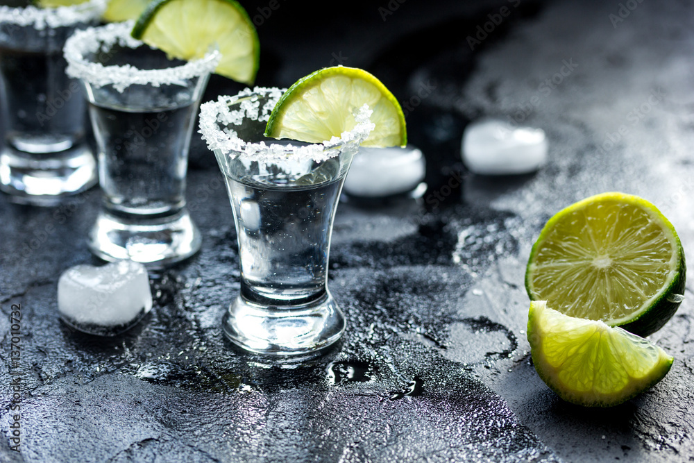 Alcohol shots with lime and salt on black background