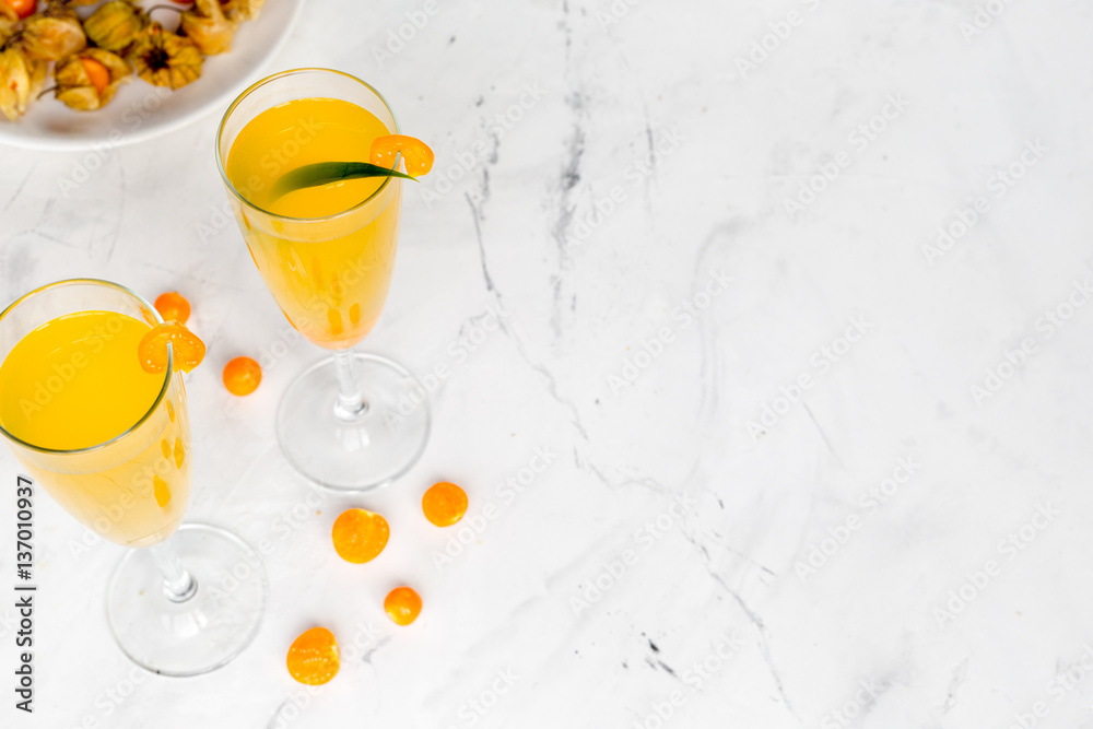 cocktail with physalis in glass on stone background