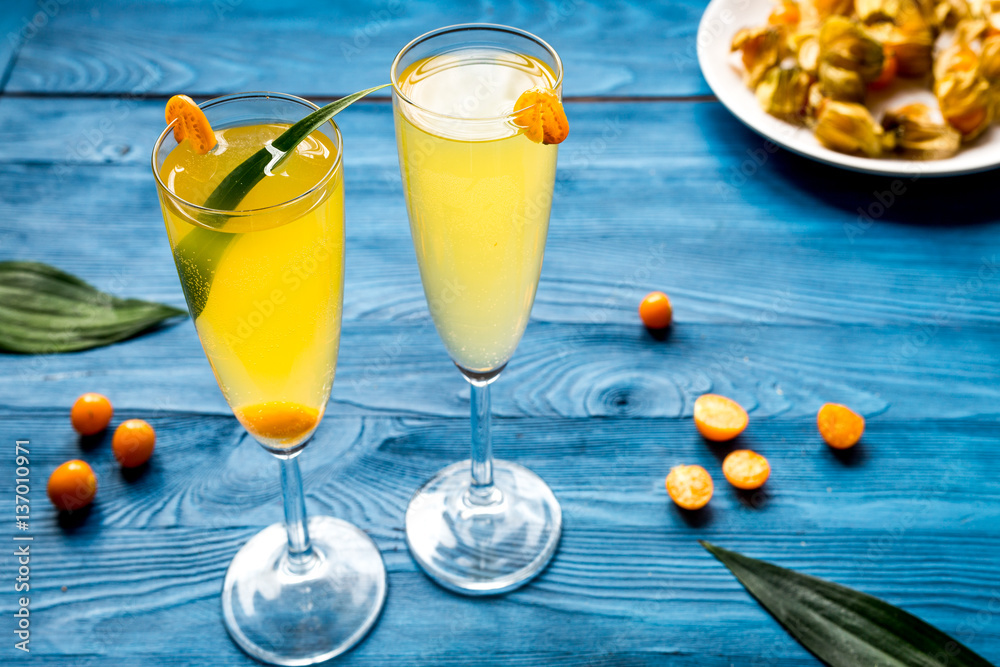 cocktail with physalis in glass on wooden background