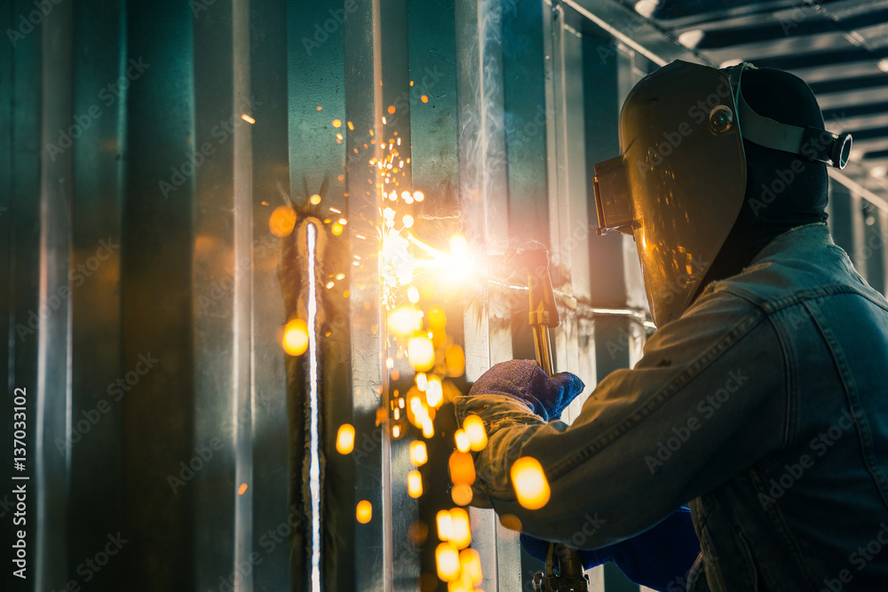 Worker cutting steel sheet by gas cutting