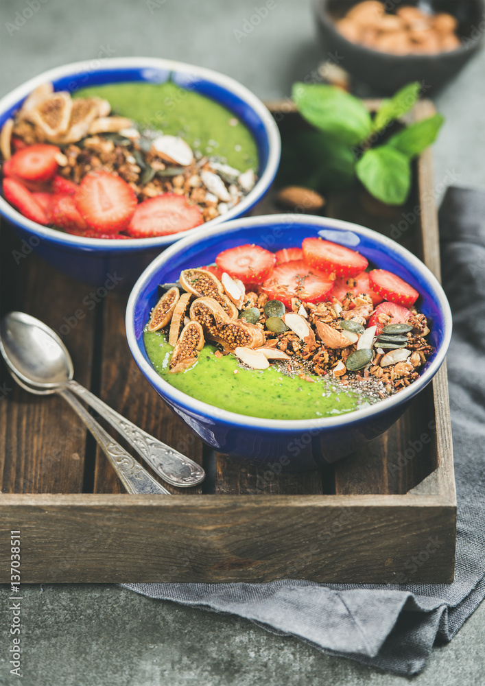 Healthy breakfast. Green smoothie bowls with strawberries, granola, chia and pumpkin seeds, dried fr