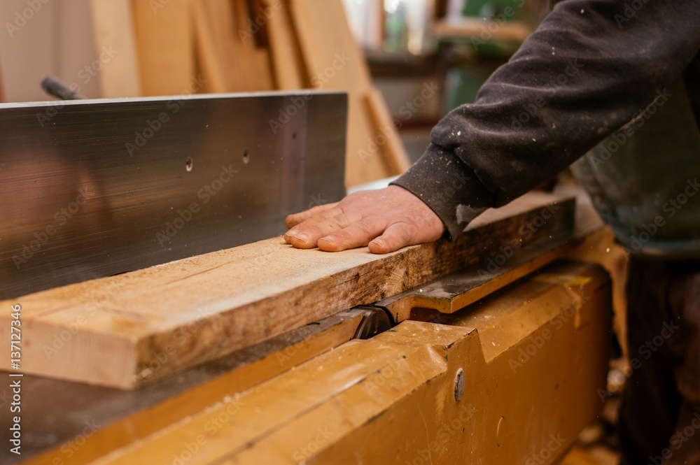 Carpenter engaged in processing wood at the sawmill.