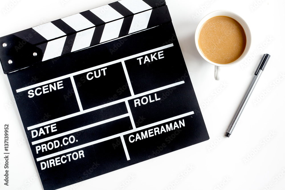 Screenwriter desktop with movie clapper board white background top view