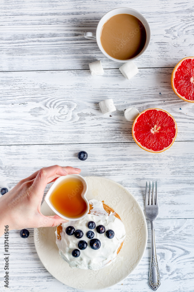 Breakfast concept with flowers on wooden background top view