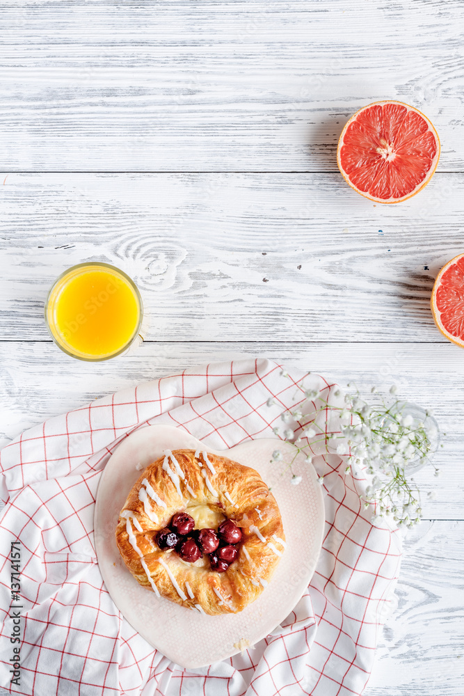 Breakfast concept with flowers on wooden background top view