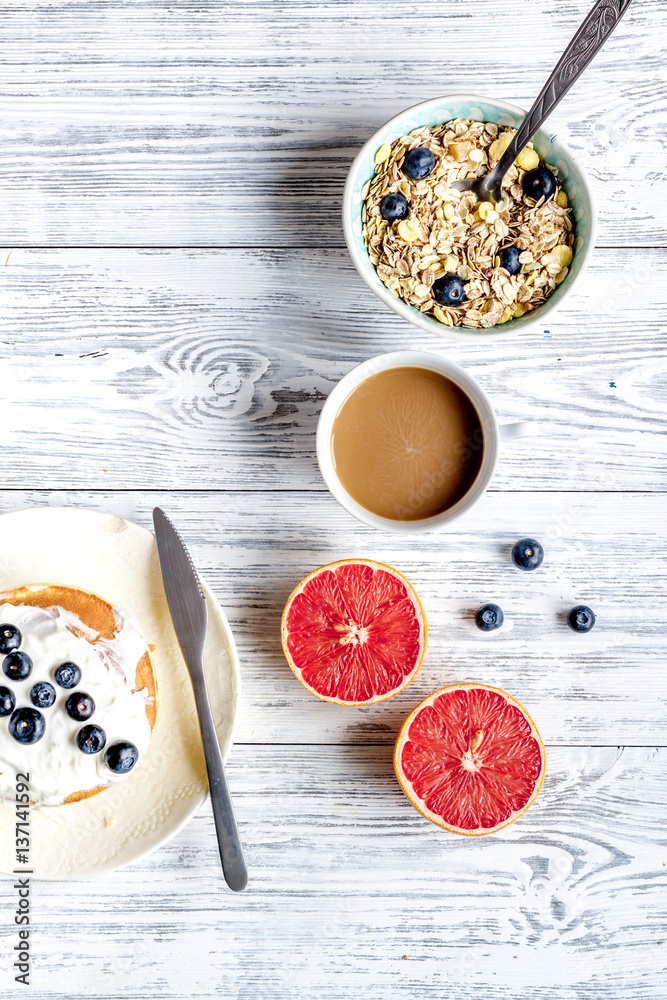 Breakfast concept with flowers on wooden background top view