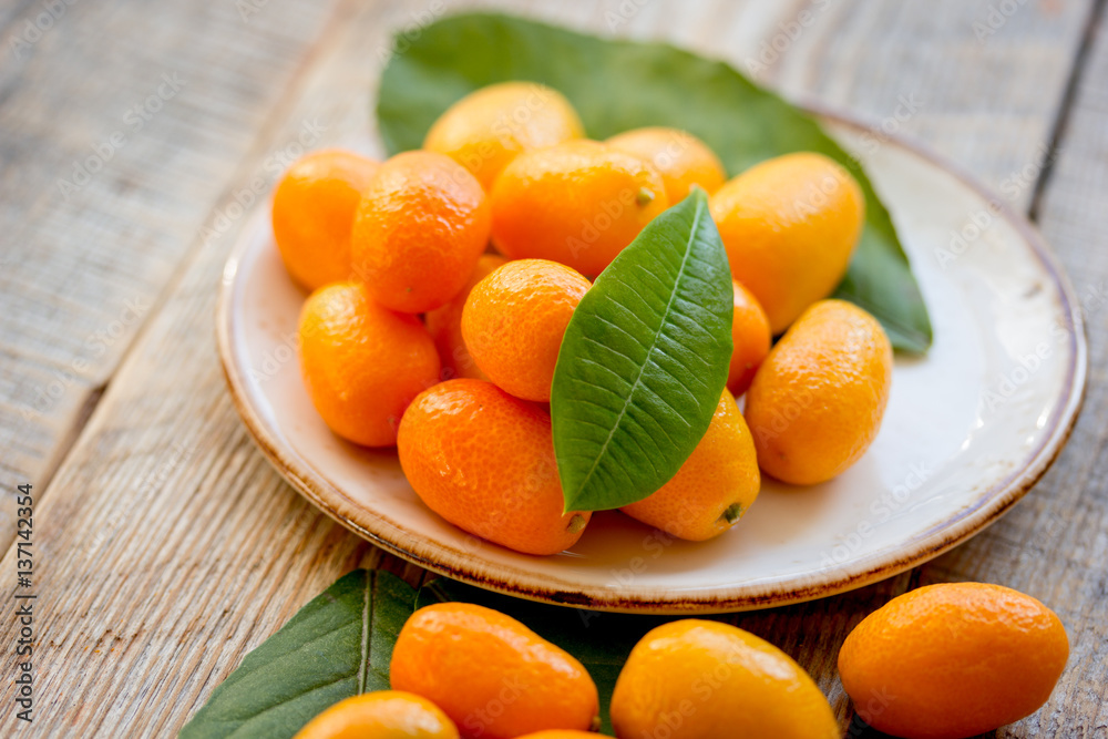 kumquat on plate at wooden table