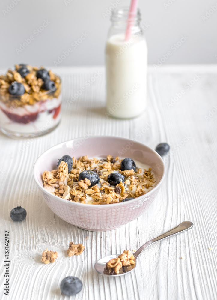 Homemade fitness granola with yoghurt and berries on white kitchen background