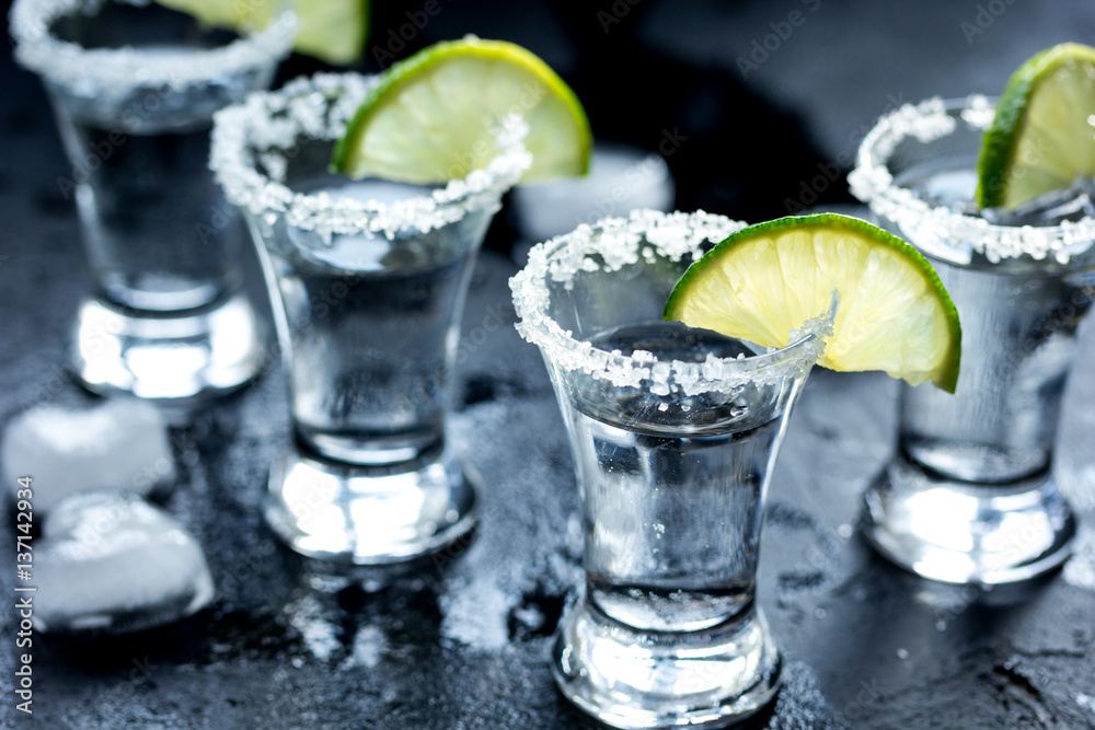 Alcohol shots with lime and salt on black background